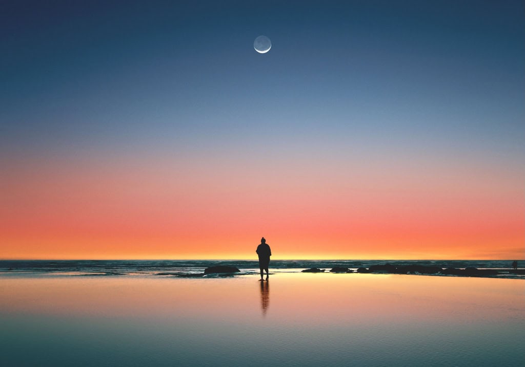 Mann am einsamen Ufer mit Mond