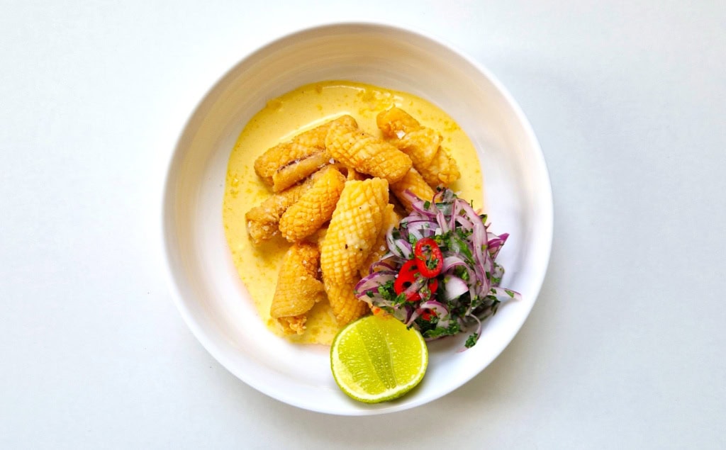 Chicharrón de calamar mit Salsa in einem weißen Teller.