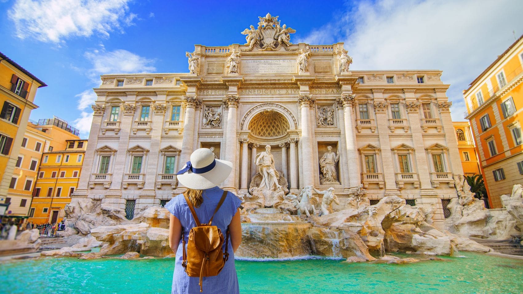 Frau mit Sonnenhut steht vor Trevi-Brunnen in Rom