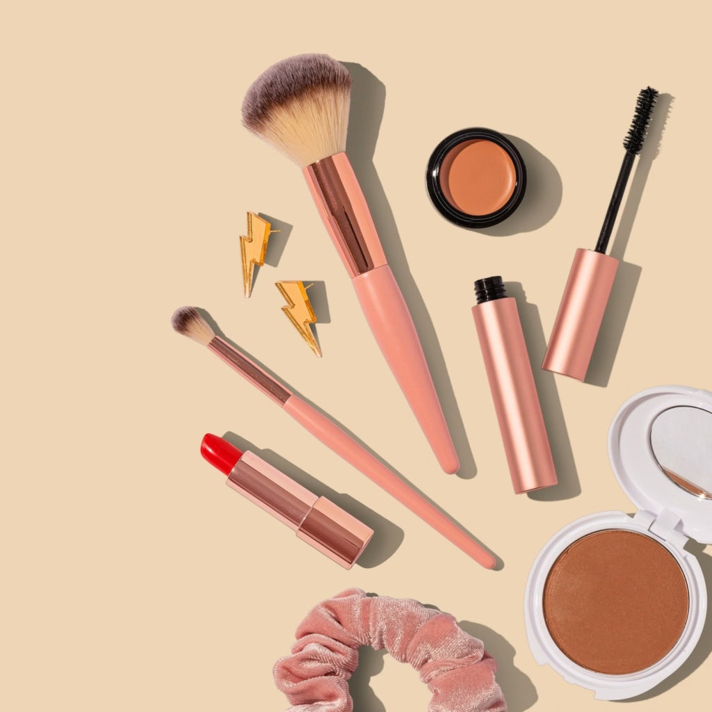 Beauty-Produkte für den Urlaub liegen auf einem hellen Untergrund