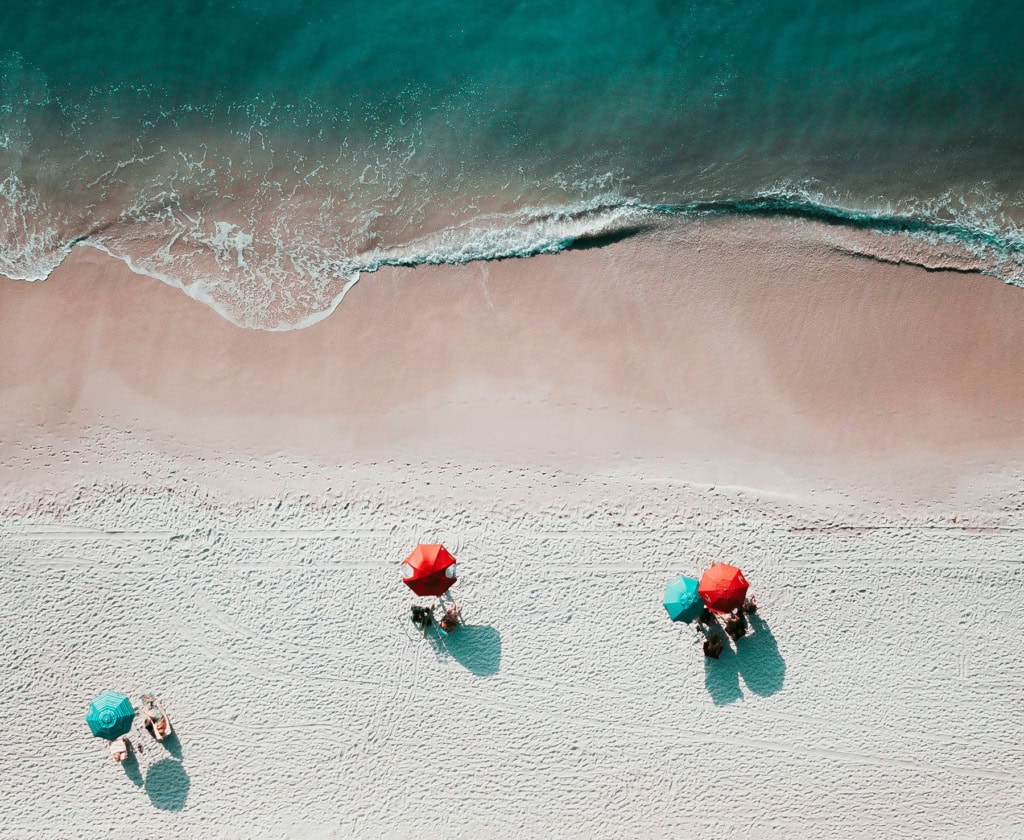 Strand in sardinien von oben mit Sonnenbadenden unter einem Sonnenschirm