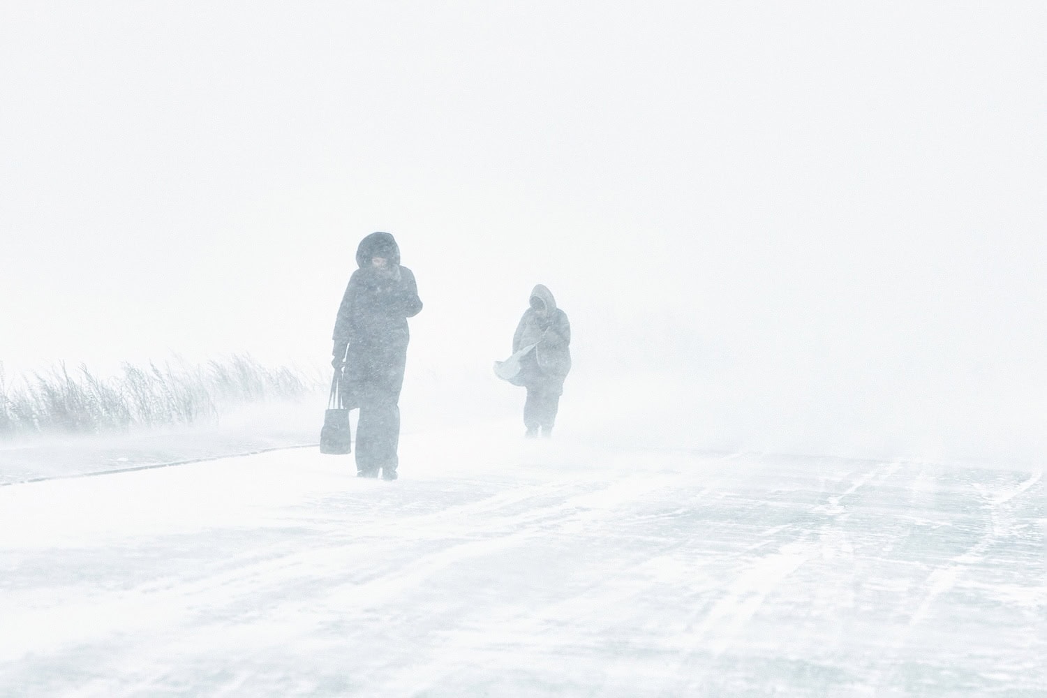 Blizzard oder Schneesturm in der Stadt mit Menschen, die versuchenüber die Straße zu laufen