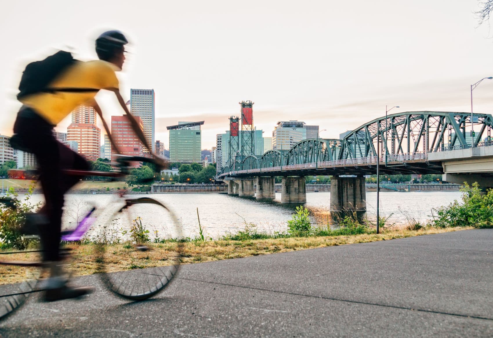 Fahrradfahrer fährt auf Promenadenweg entlang des Flusses in Portland, Oregon, USA