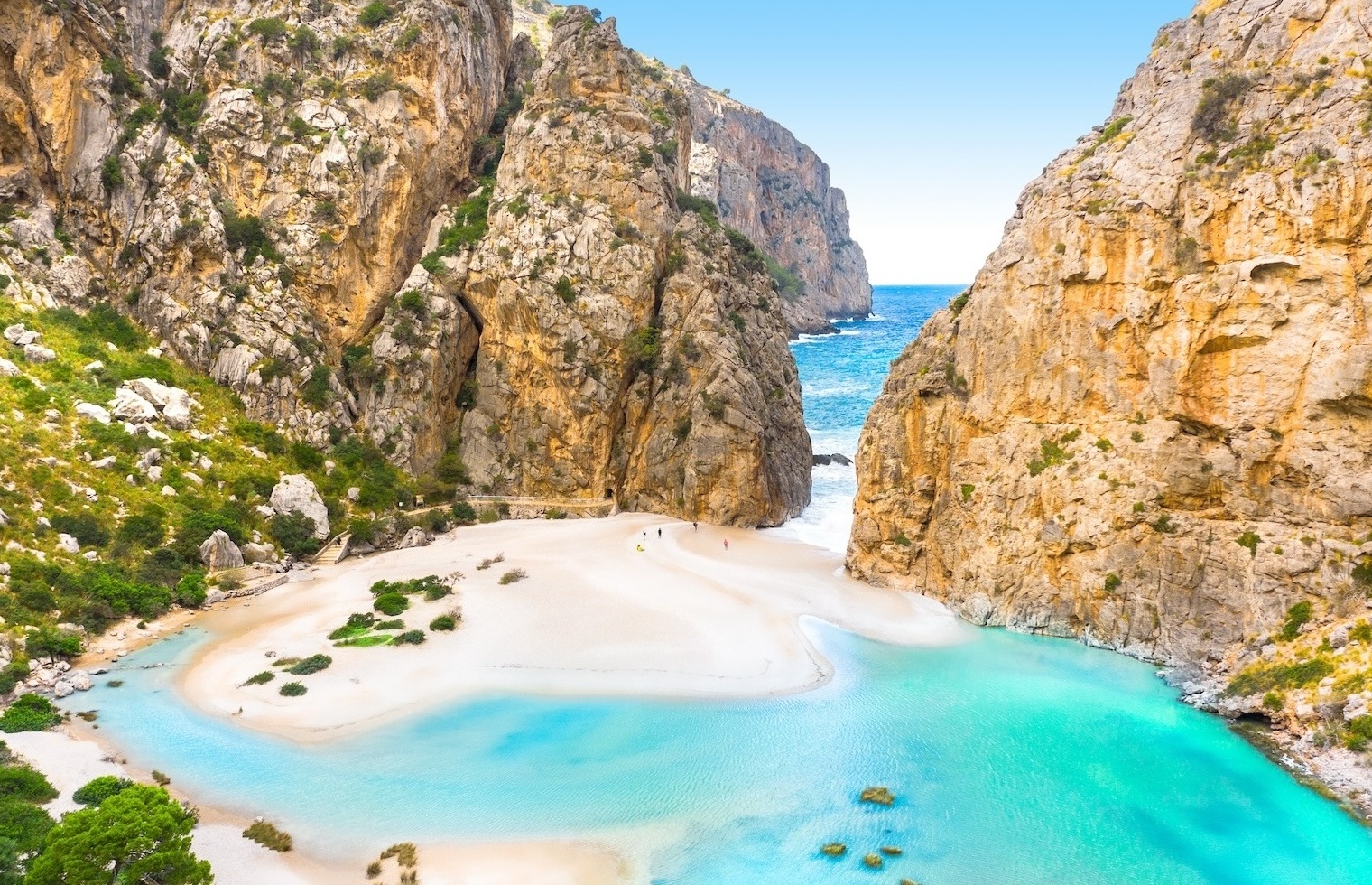 Torrent de Pareis auf Mallorca; zwei Klippen, die beinahe aneinander stoßen und nur einen schmalen Durchgang lassen, dazwischen eine Sandbank