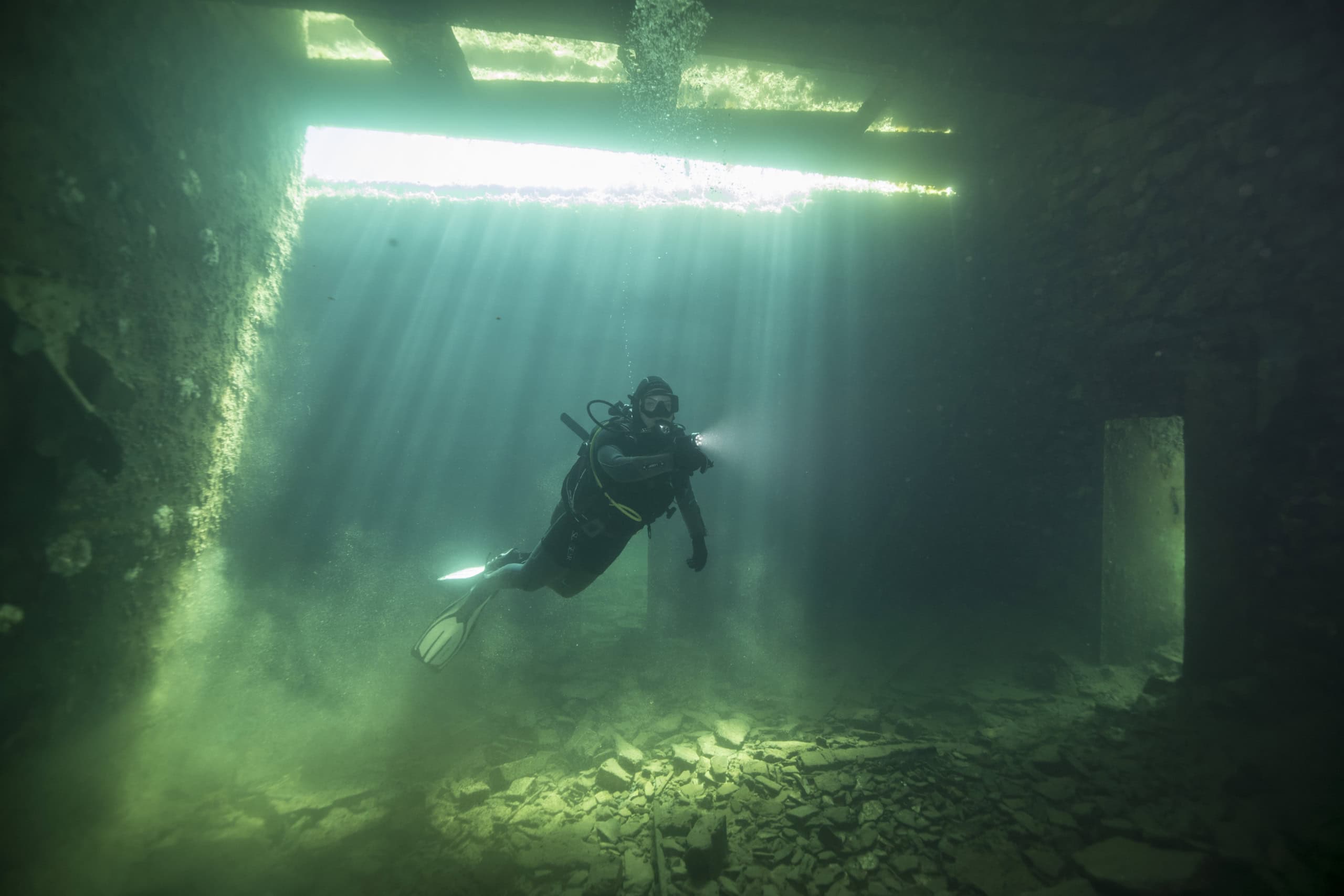 Ein Taucher schwimmt in Estland durch ein versunkenes Gefängnis.