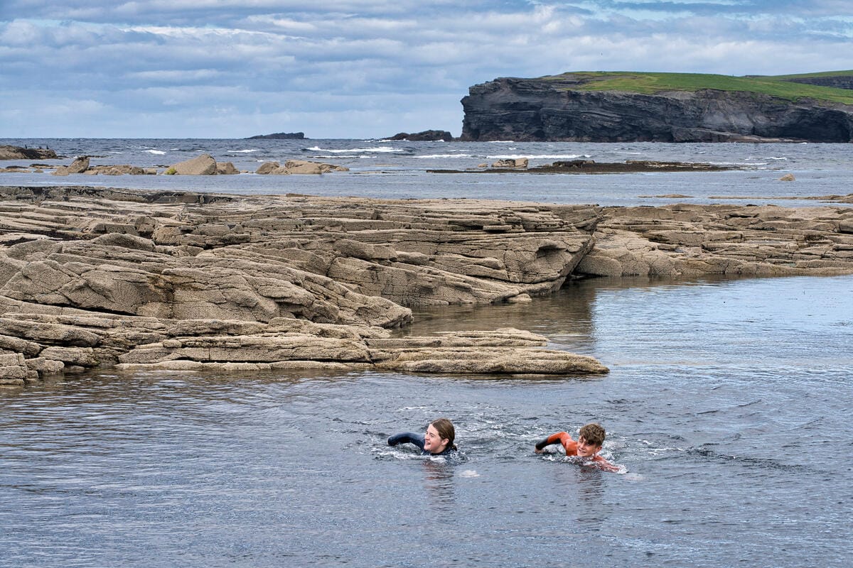 Zwei frauen schwimmen im kalten Wasser von Kilkee Bay