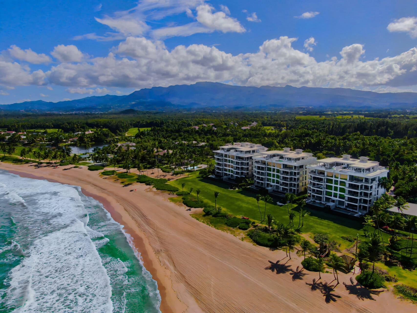 Four Seasons Dronenaufnahme, Strand, Hotelkomplex, Urwald, im Hintergrund Berge