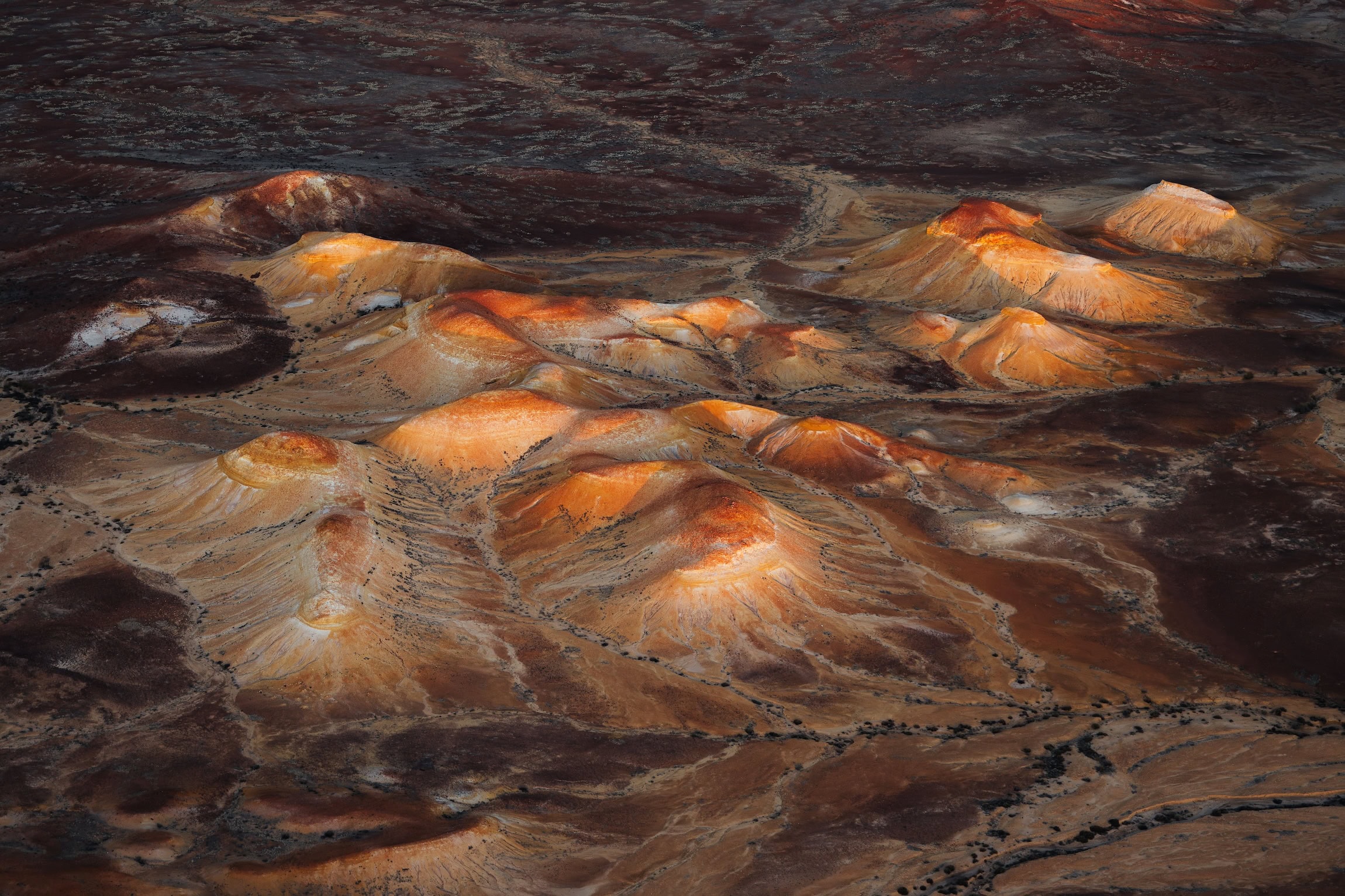 Die Anna Creek Painted Hills aus der Luft; die Hügel aus Bundsandstein sehen aus wie mit einem Pinsel in die Landschaft getupft