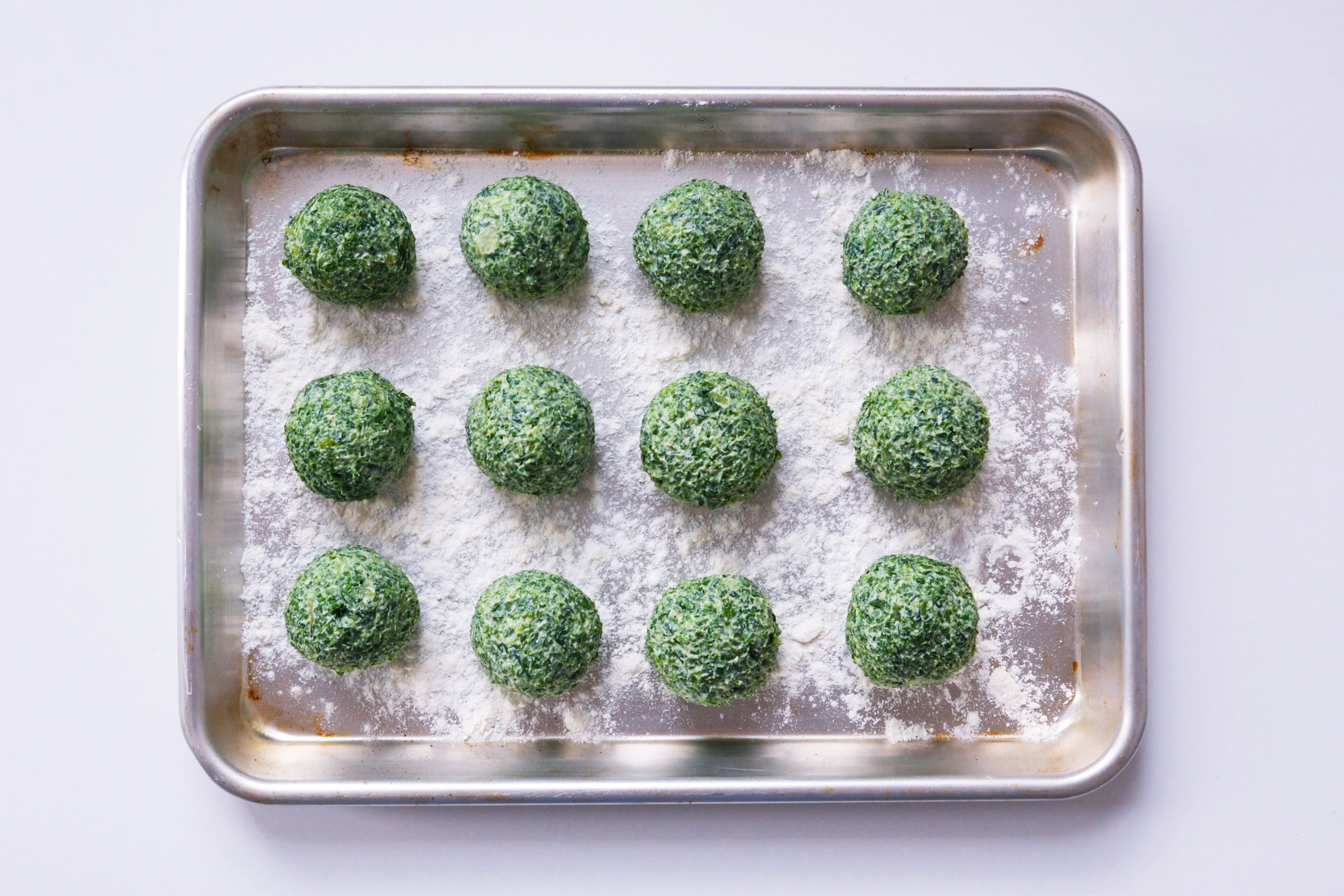 Grünkohl-Gnudi auf einem silbernen Tablett. In unserem Gnudi-Rezept trifft Norddeutschland auf Toskana.