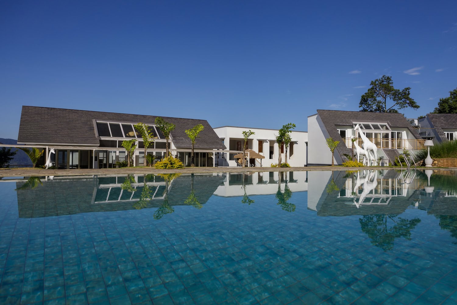 Mehrere kleine Gebäude, im Vordergrund ein großer Pool.
