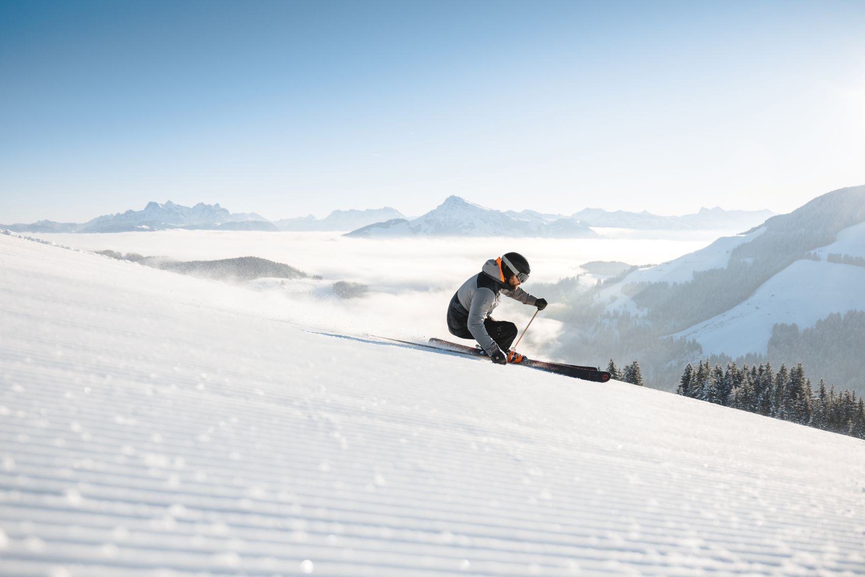 Skifahrer düst Piste am Wilden Kaiser hinab