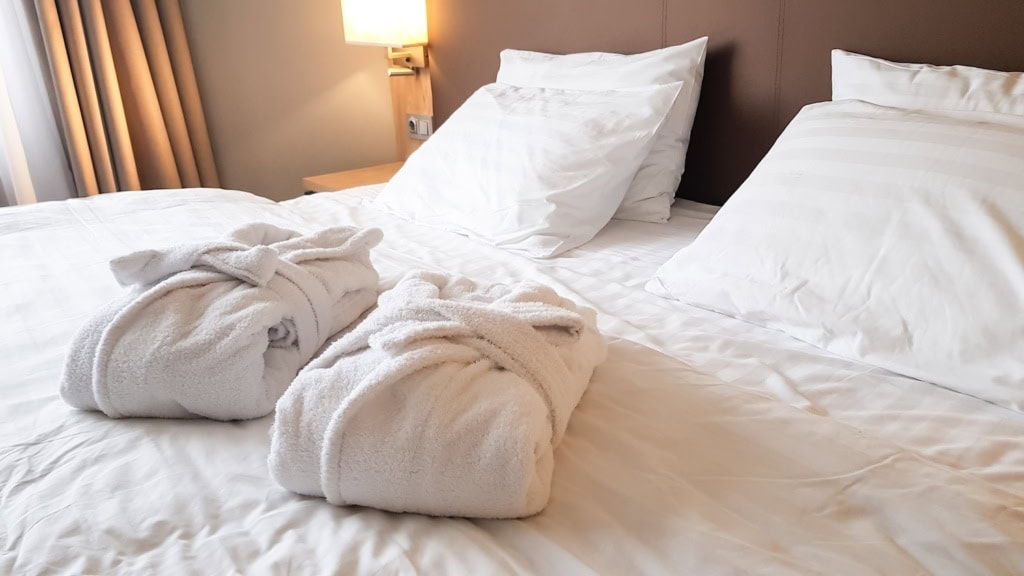 zwei Bademäntel auf dem Bett im Hotel