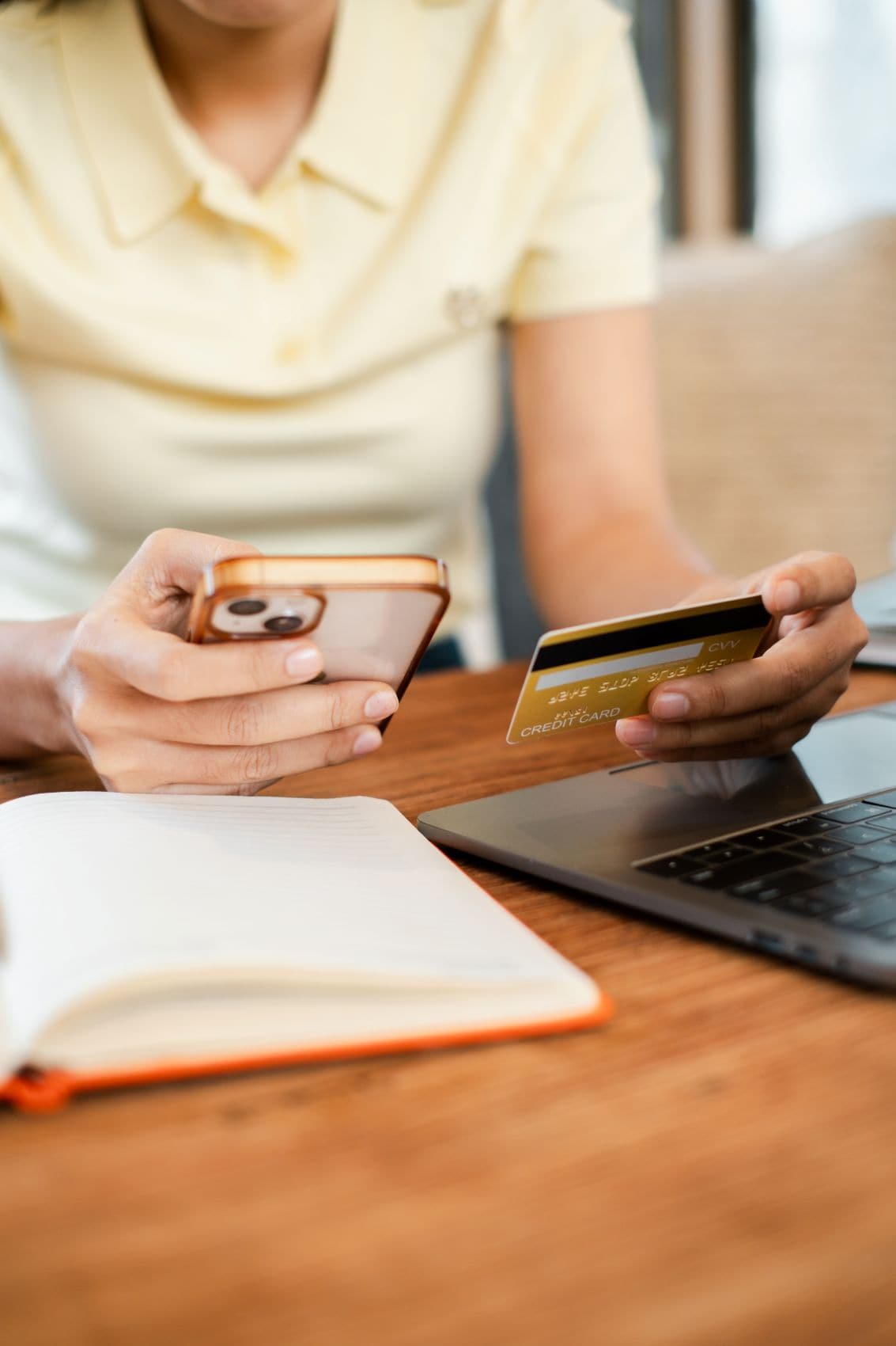 Frau, die ein Smartphone und eine Kreditkarte für den Online-Einkauf verwendet 