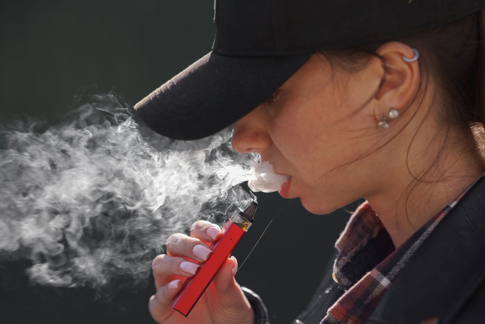 Junge Frau raucht eine Vape