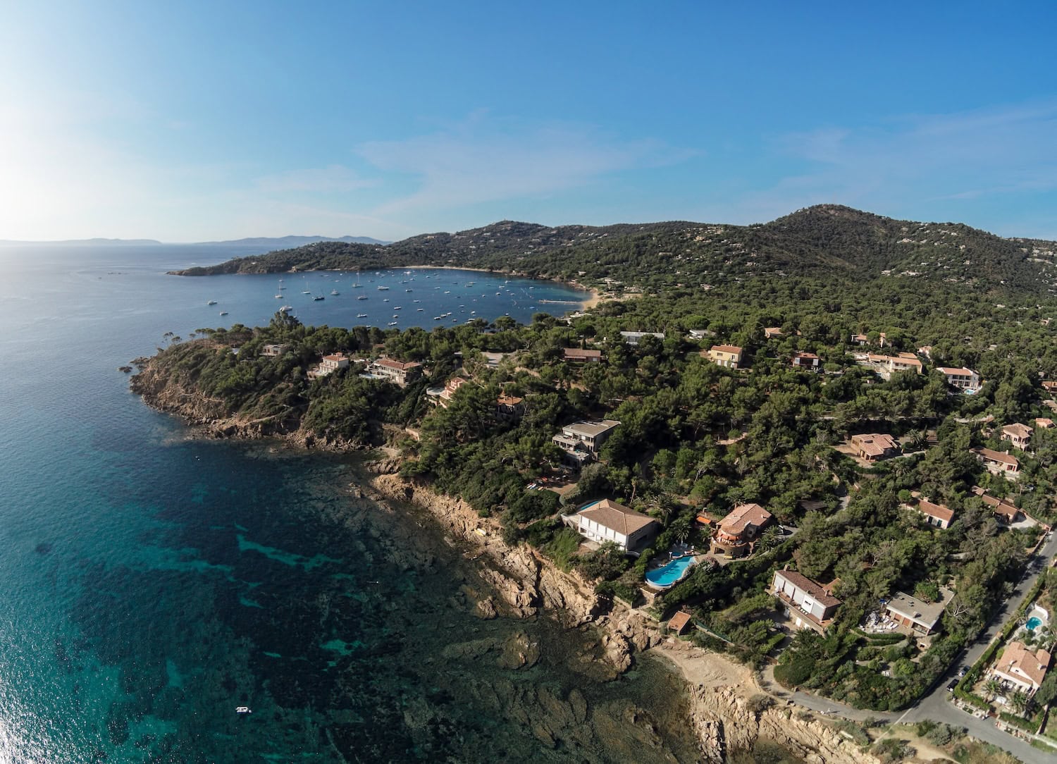 Cote Azur von oben, blaue Meeresbuchten, Ausläufer der Seealpen und einzelne Villen inmitten der Natur.