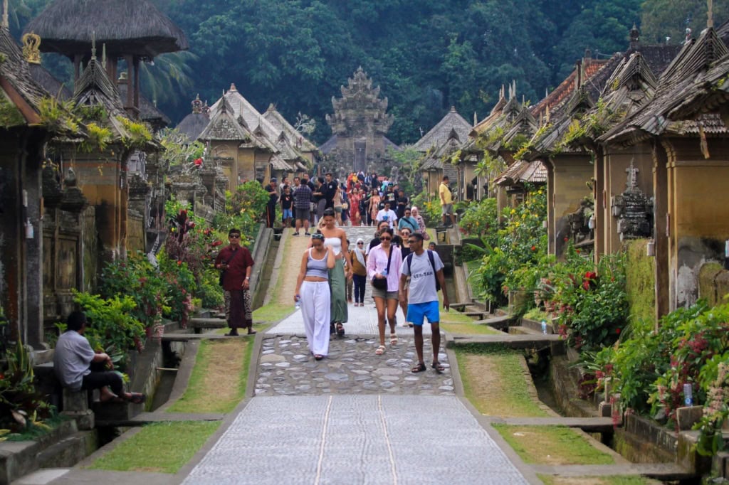 Touristen flanieren durch das Penglipuran Village auf Bali