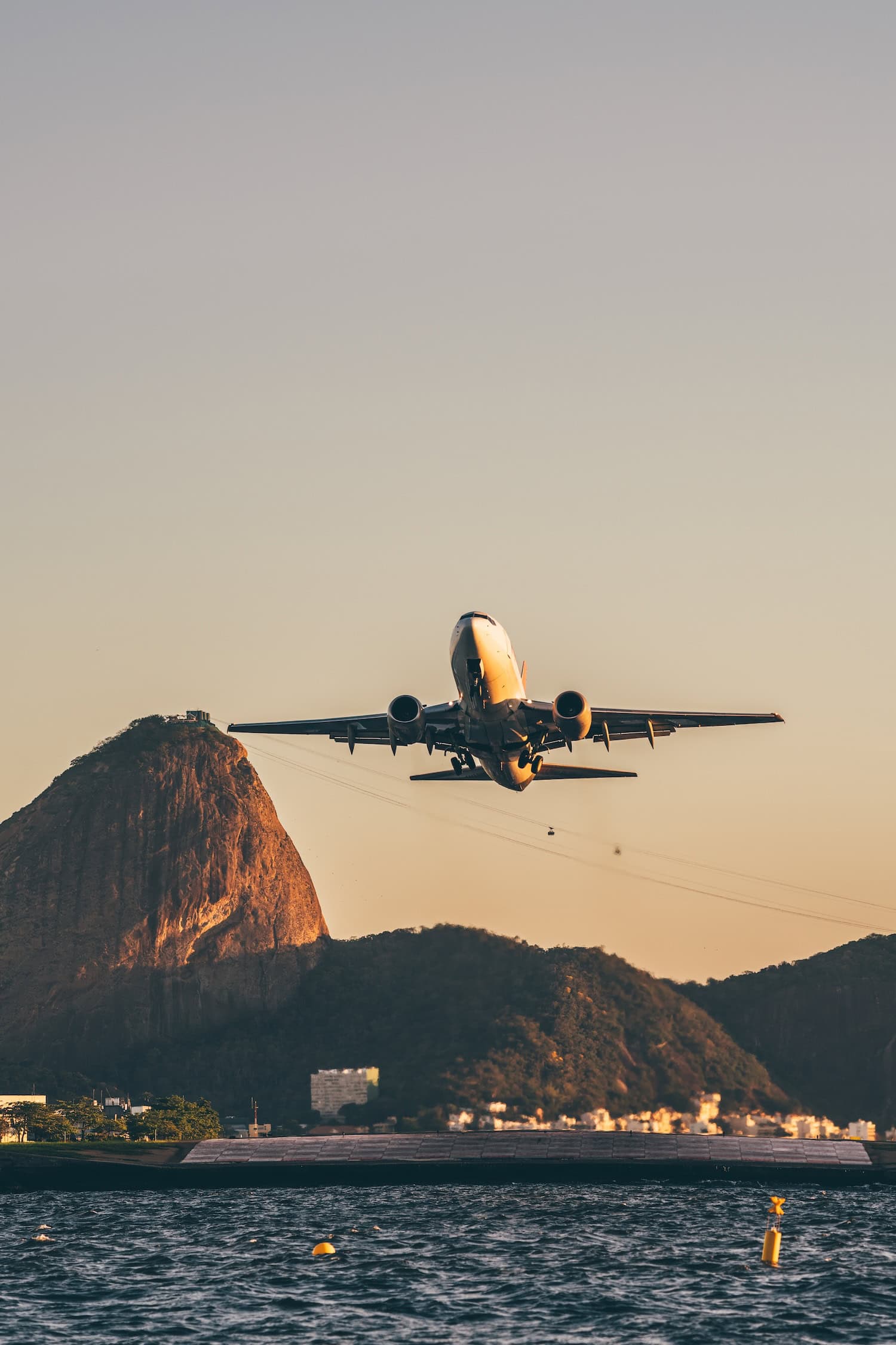 Flugzeug über Rio de Janeiro, im Hintergrund ist der Zuckerhut zu sehen, unten das Meer.