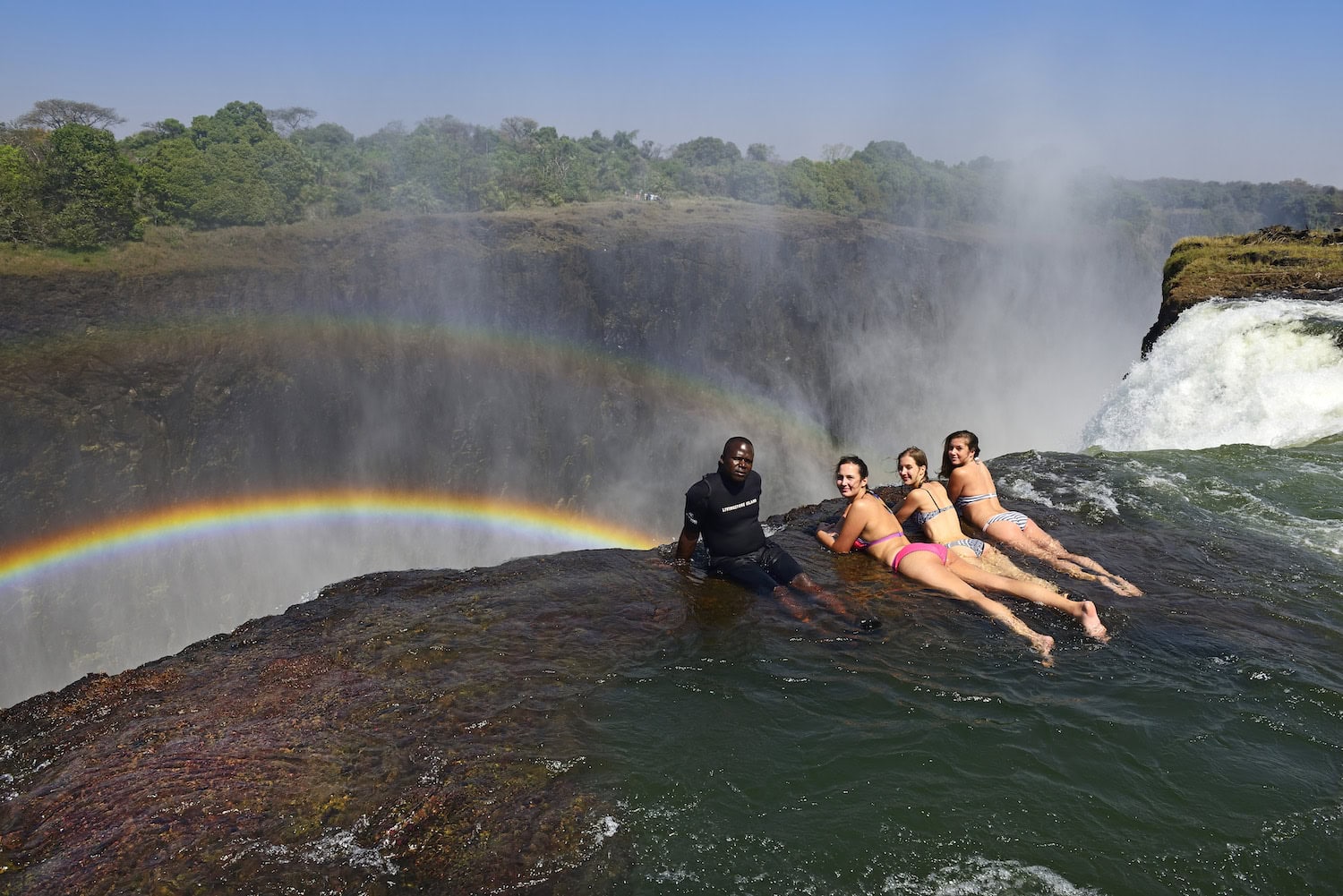 Frauen baden an den Victoriafällen