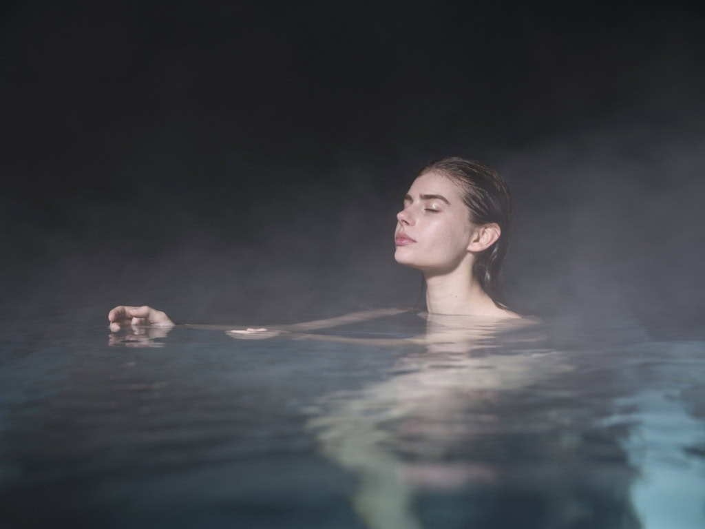 Frau badet in heißem Thermalwasser
