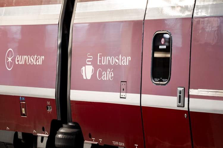 Detailaufnahme eines roten Eurostar-Zugs; Neben einer Zugtür ist die Aufschrift "Eurostar Café" auftragen.