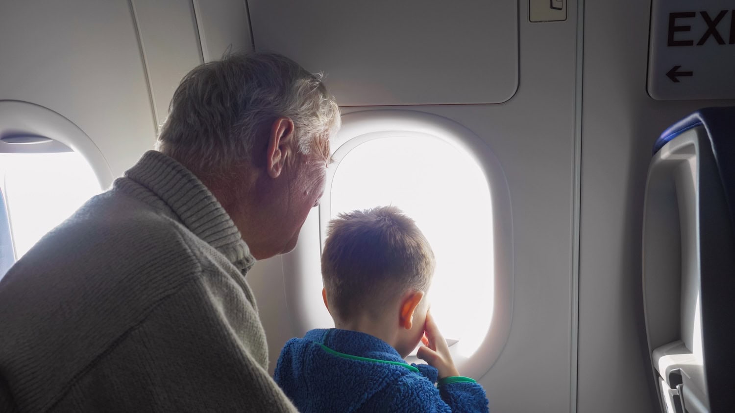 ein Großvater mit Kleinkind im Flugzeug