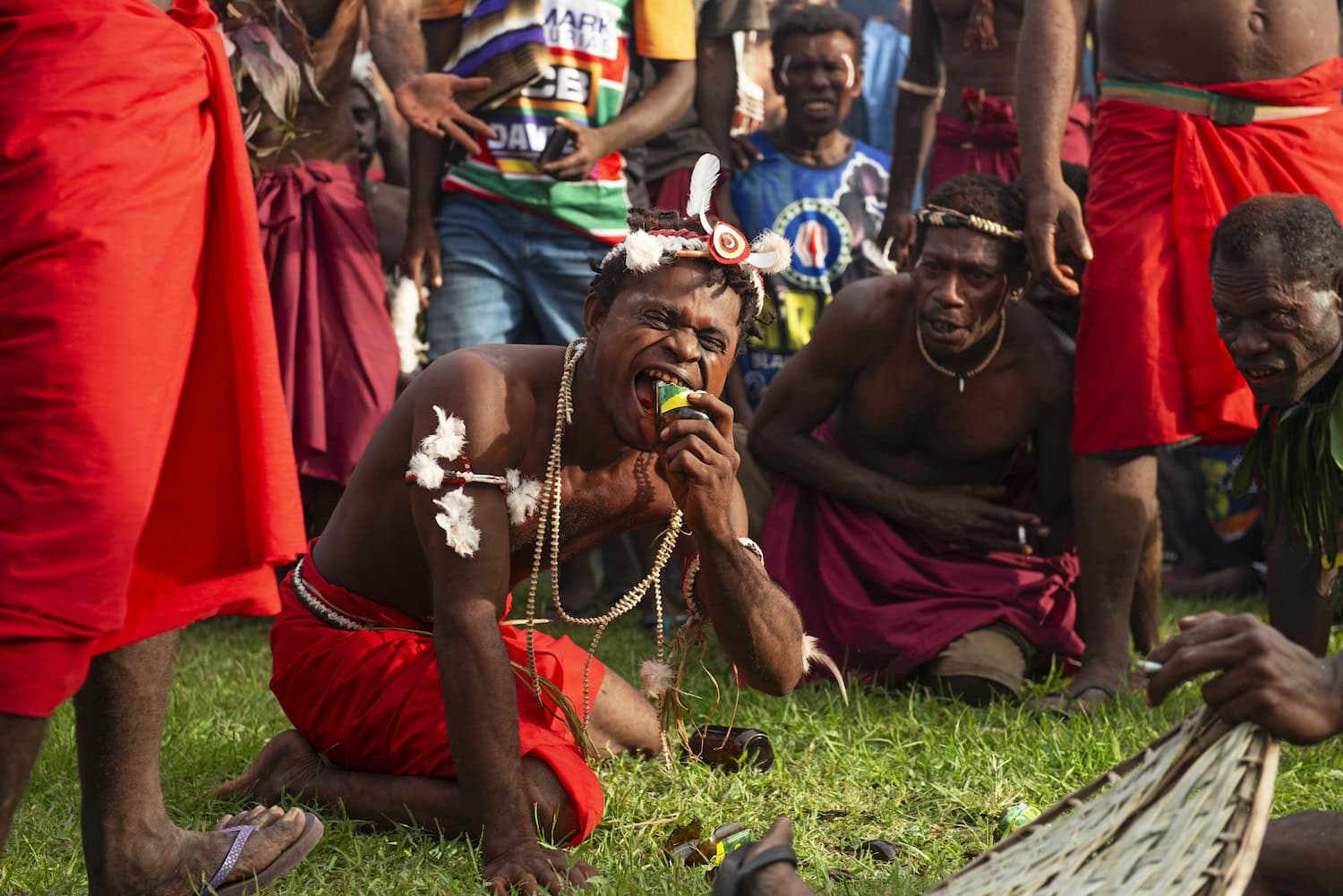 Mann aus der Gruppe der Virjan auf Papua-Neuguinea verbeißt eine Bierflasche beim Kokopo Maskenfest