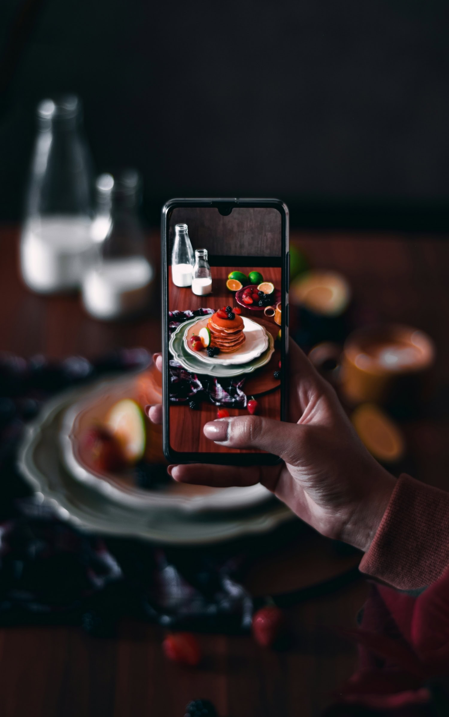 Mensch fotografiert Pancakes mit dem Handy