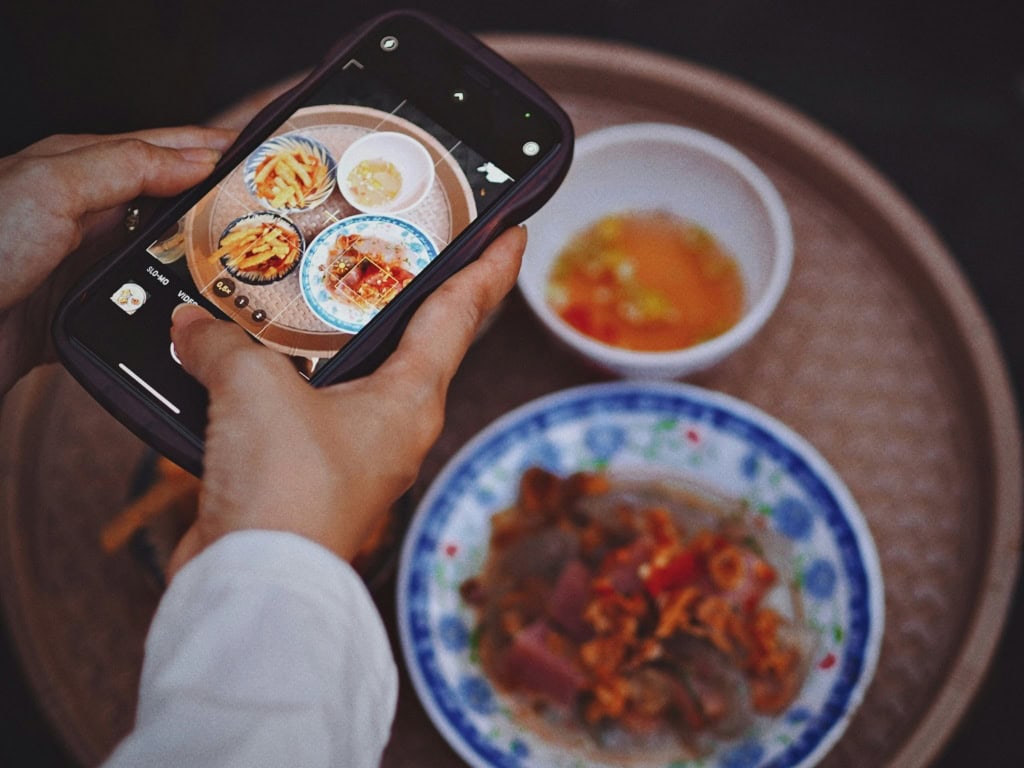 eine Person fotografiert auf Reisen das Essen für Instagram