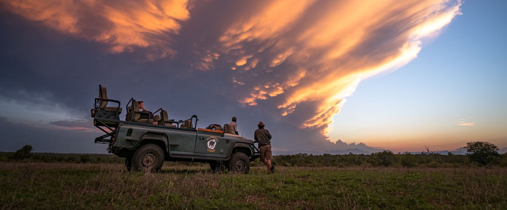 Safari-Jeep mit Touristen in Südafrika in der Abenddämmerung