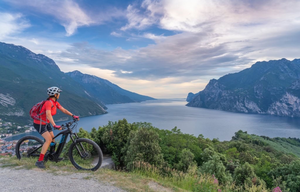 Frau mit Mountainbike auf einem Berg mit Blick über den Gardasee