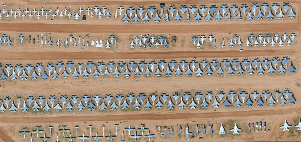 Drohnenansicht des Flugzeugfriedhofs »Boneyard« in Arizona. In der Wüste stehen zahllose ausrangierte Militärflugzeuge nebeneinander.
