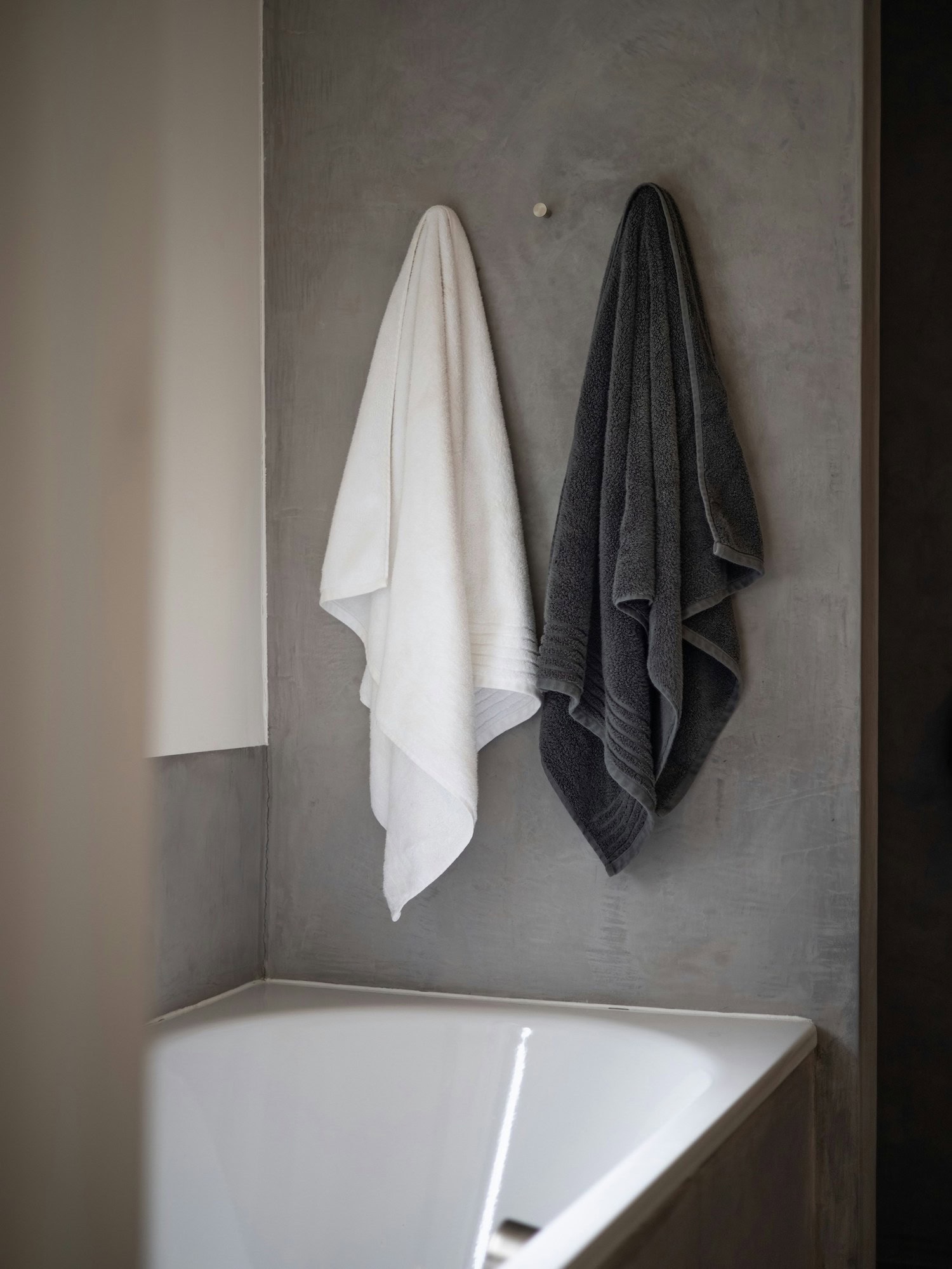 zwei Handtücher hängen über einer Badewanne