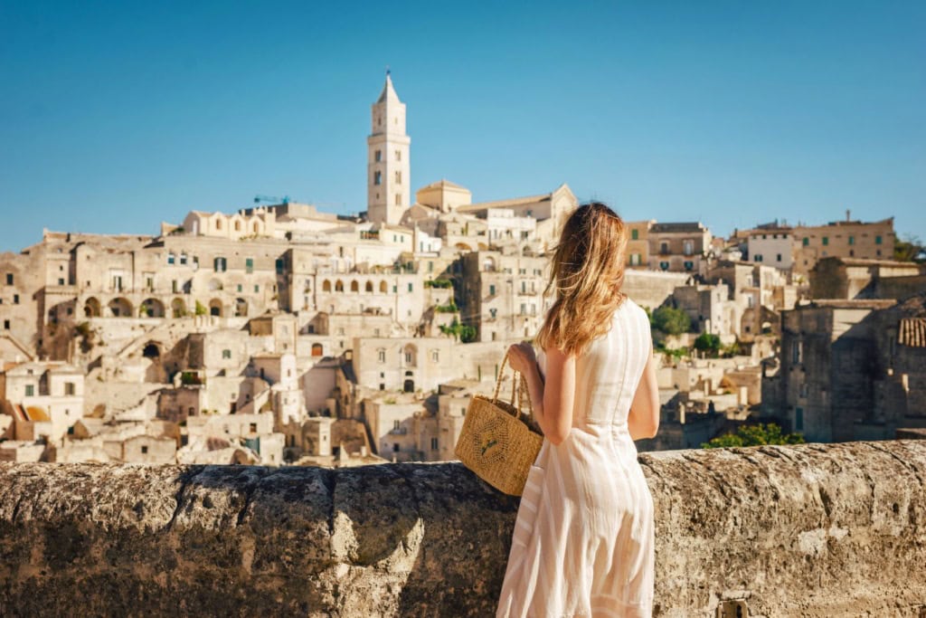 Junge Frau blickt auf die Kulisse der Stadt Matera in Italien