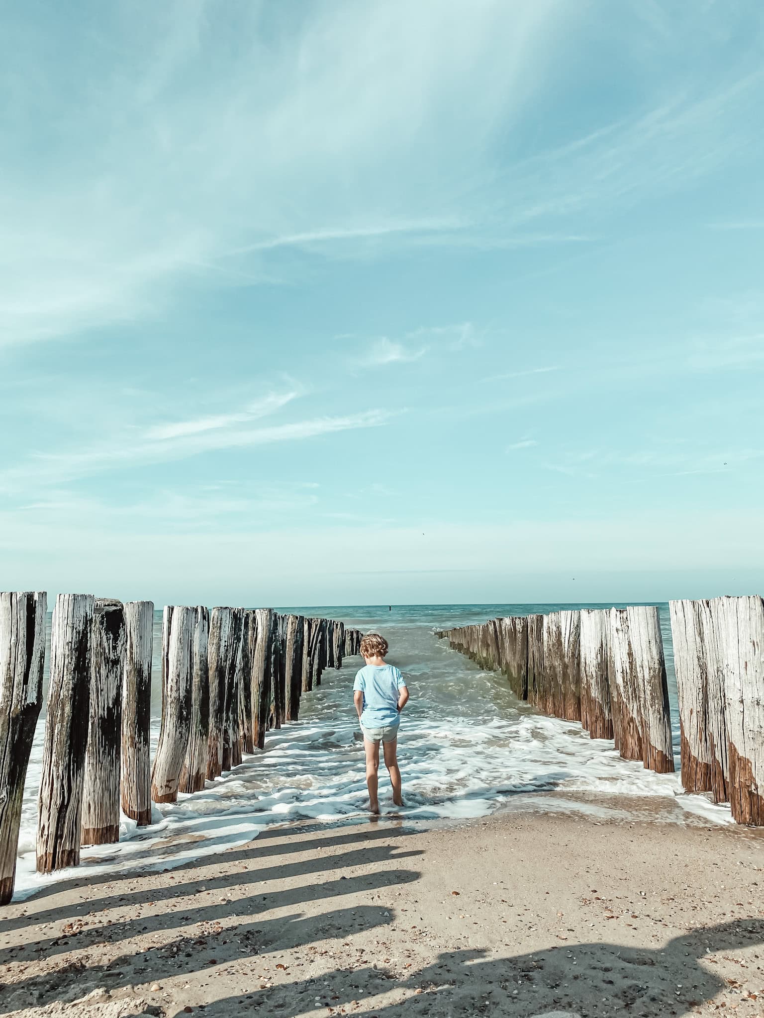 Familienurlaub in Zeeland: Kind steht am Meer