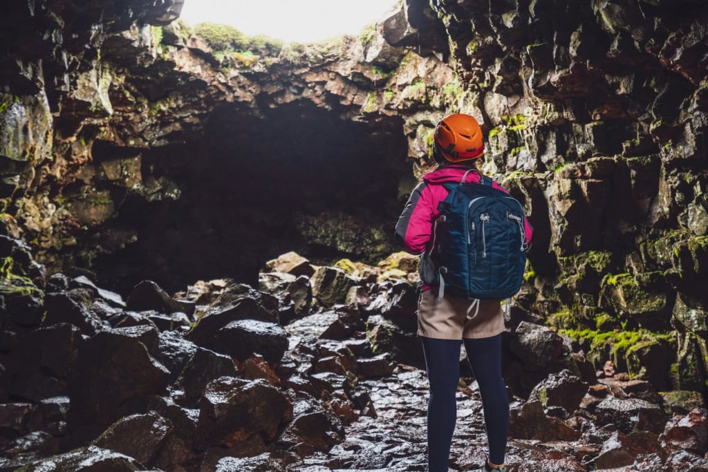 Frau steht am Eingang einer Höhle in Deutchalnd