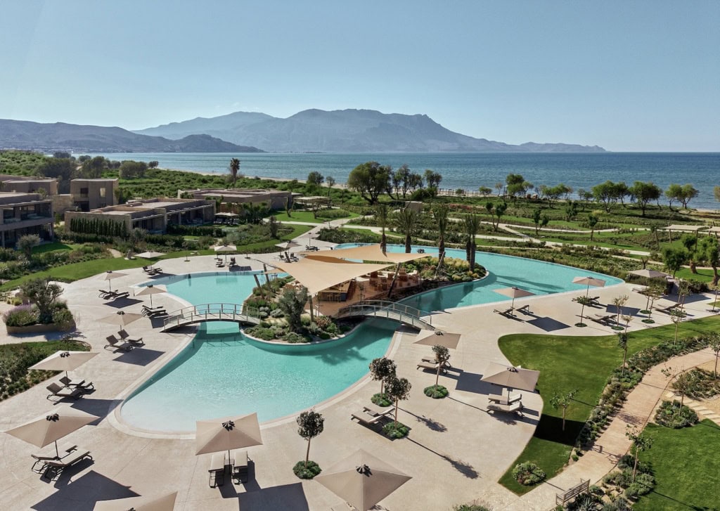 Poolanlage des Resorts Ikos Kissamos auf Kreta, im HIntergrund das Meer und die Berge.