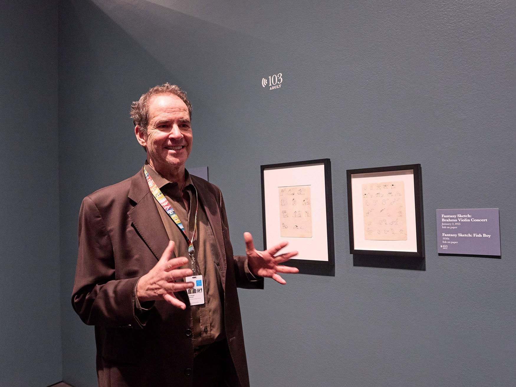 Der Direktor des Denver Art Museums, Christoph Heinrich, steht mit offenen Händen vor zwei Bildern in seinem Museum.