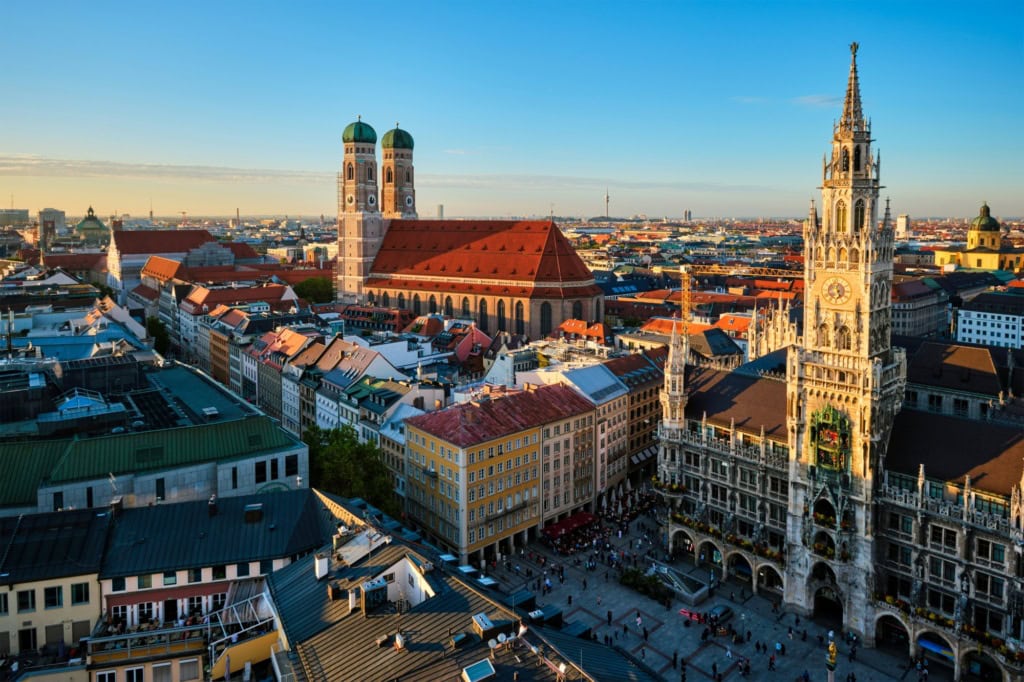 Panoramaaufnahme Münchens mit dem Marienplatz und der Frauenkirche im Licht der aufgehenden Sonne