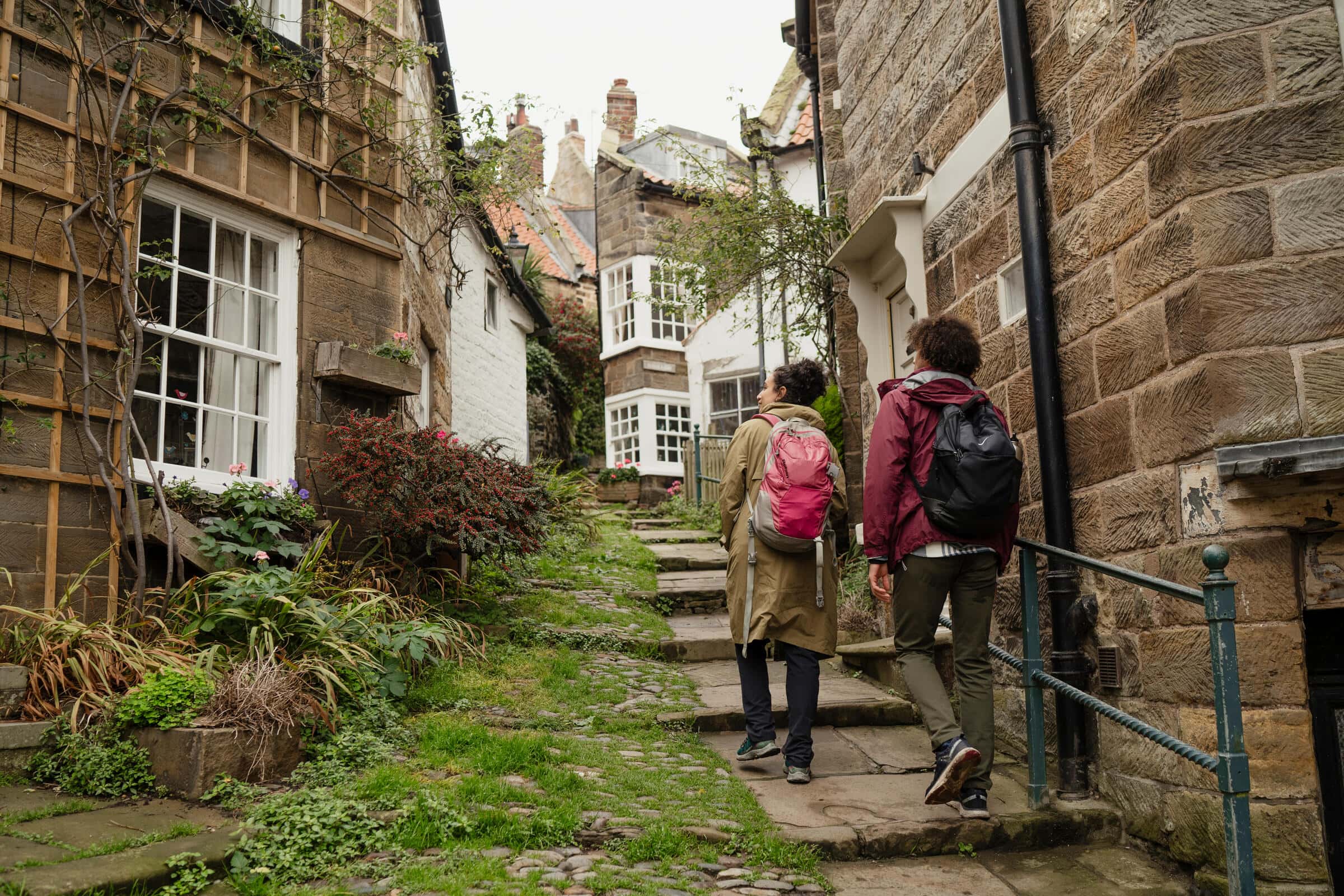 Ein Paar läuft durch Robin Hood's Bay, North Yorkshire.