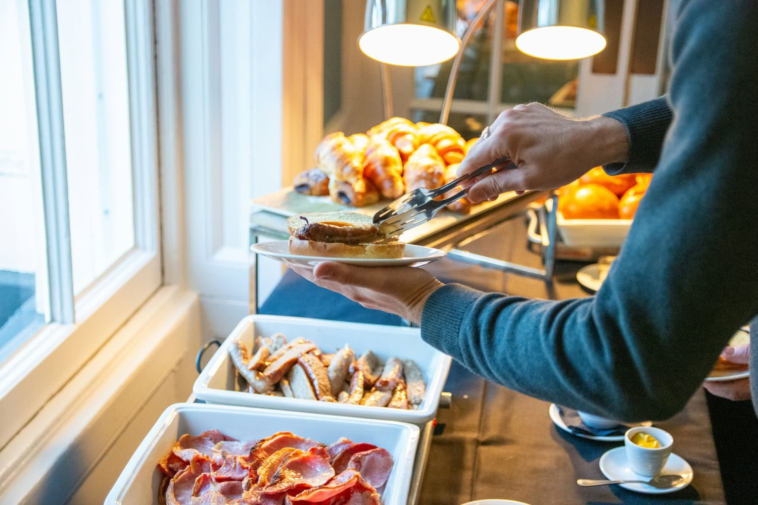 Mannd er sich am Hotelbüffet zum Frühstück bedient