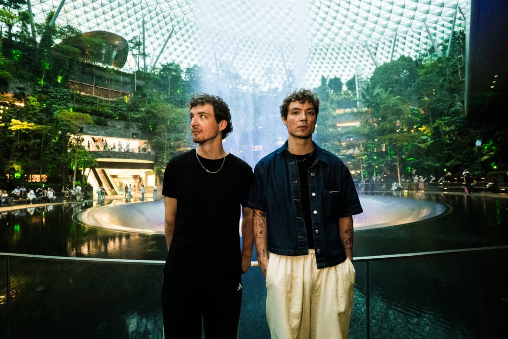 Heiko und Roman Lochmann stehen vor dem Wasserfall und der begrünten Glaskuppel im Jewel Changi Airport in Singapur.