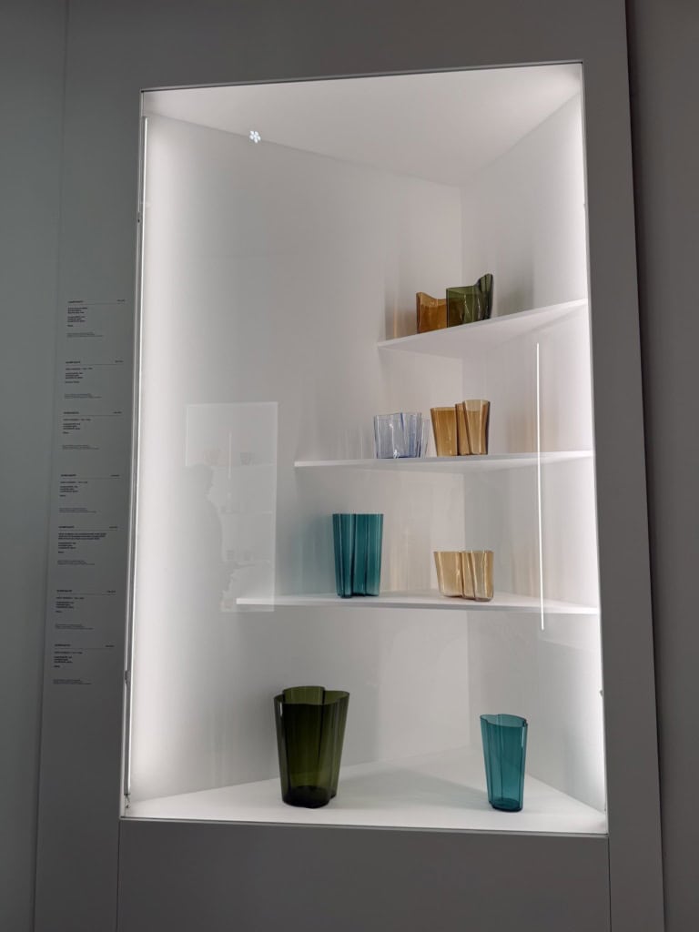 Mehrere bunte Aalto-Vasen in einer Ausstellungsvitrine.