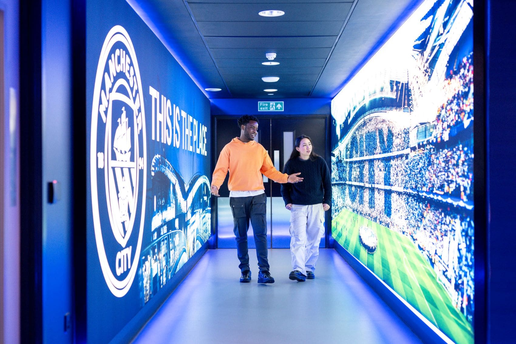Ein junges Paar erkundet die Innenräume im Manchester City Stadion 