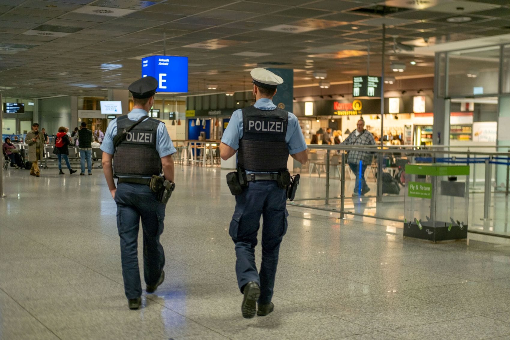 Zwei deutsche Polizisten patrouillieren im Flughafen-Terminal. 