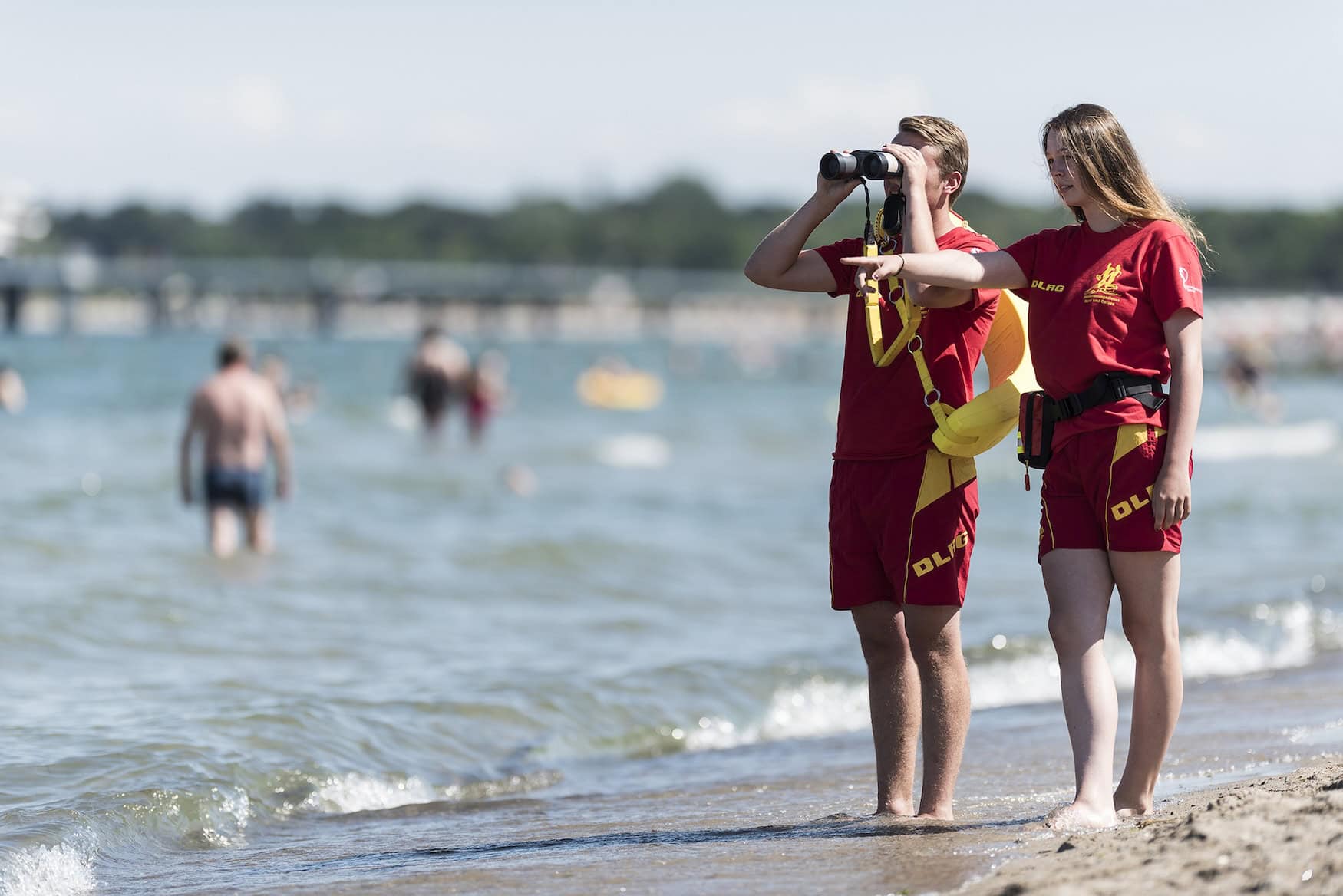 Zwei DLRG-Rettungskräfte beobachten die Lage im Wasser.