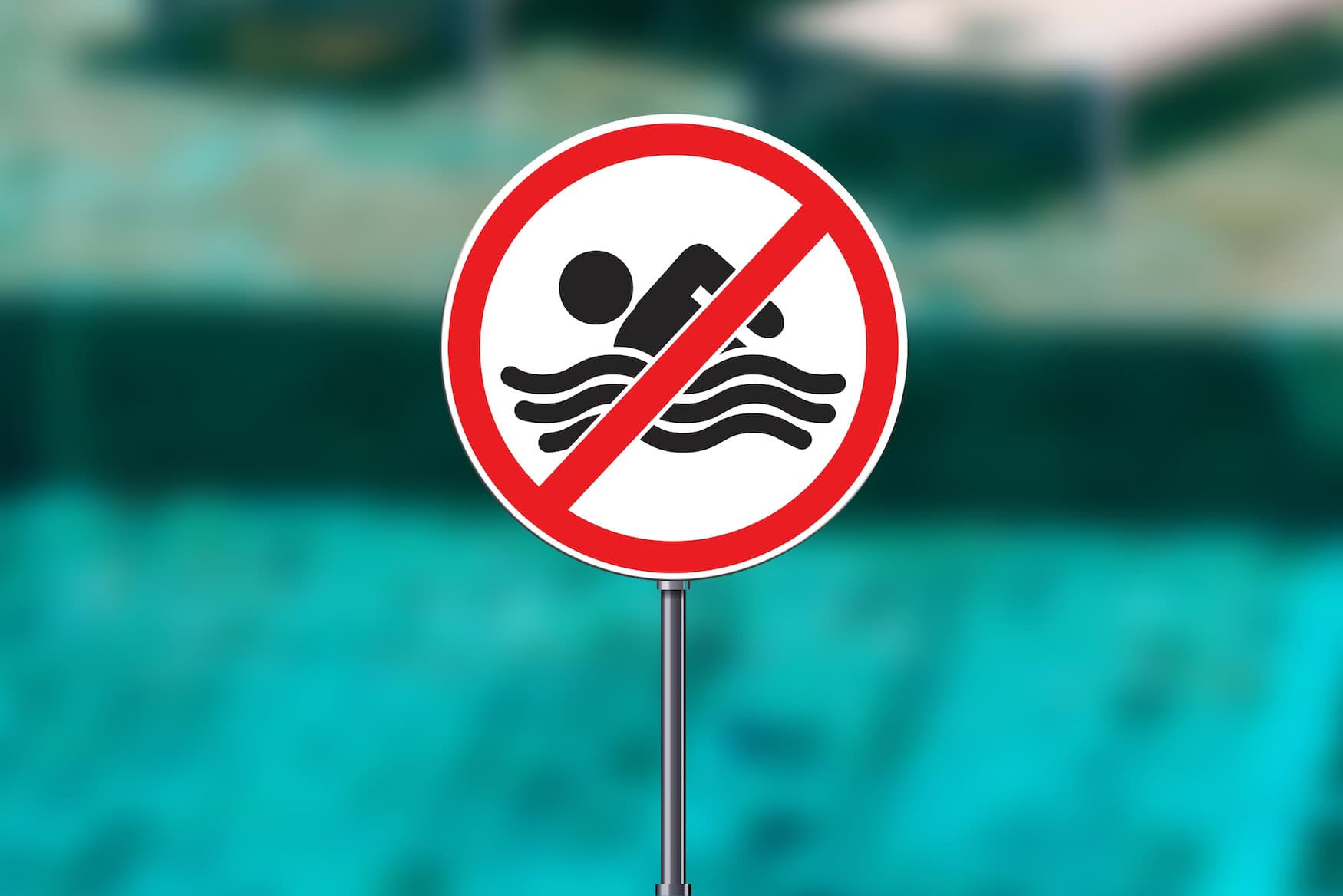 Ein "Nicht schwimmen"-Schild an einem Gewässer.